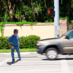 A man is jaywalking across an intersection when the signal is clearly showing the do not cross symbol.